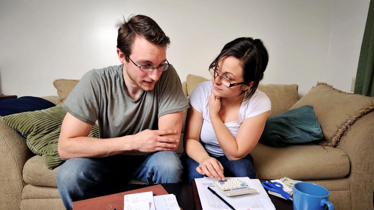 Young apartment-dwelling couple working on household budgetary matters, complete with a "past due" invoice and some tough choices.