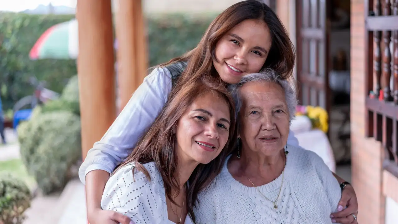Portrait of grandmother, daughter and granddaughter facing camera smiling very cheerfully