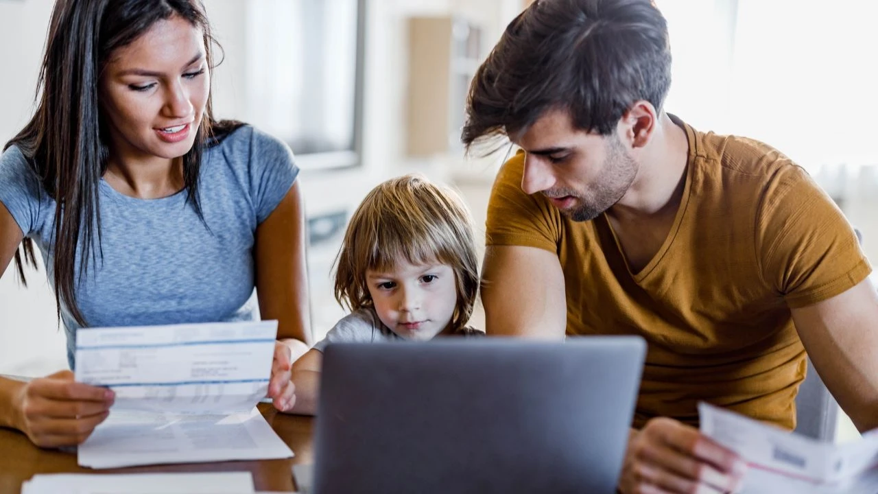 Happy family paying bills over a computer at home.