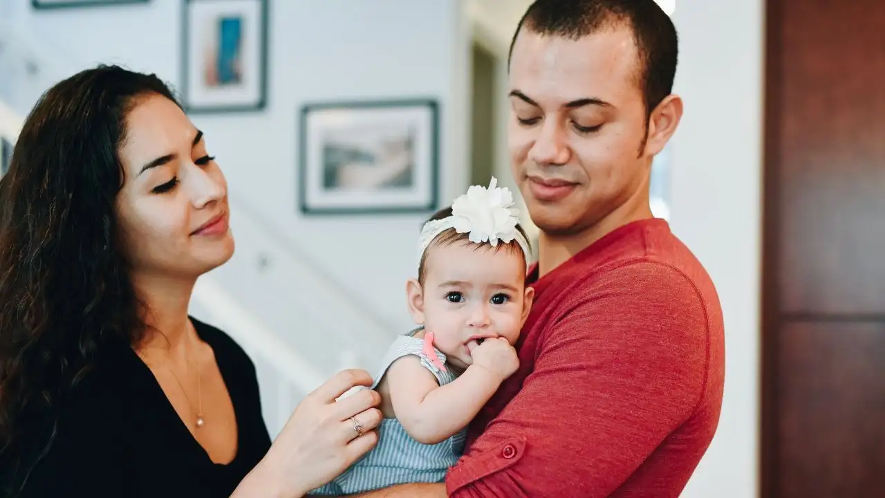 Young Latinx family spending time at home with their baby daughter