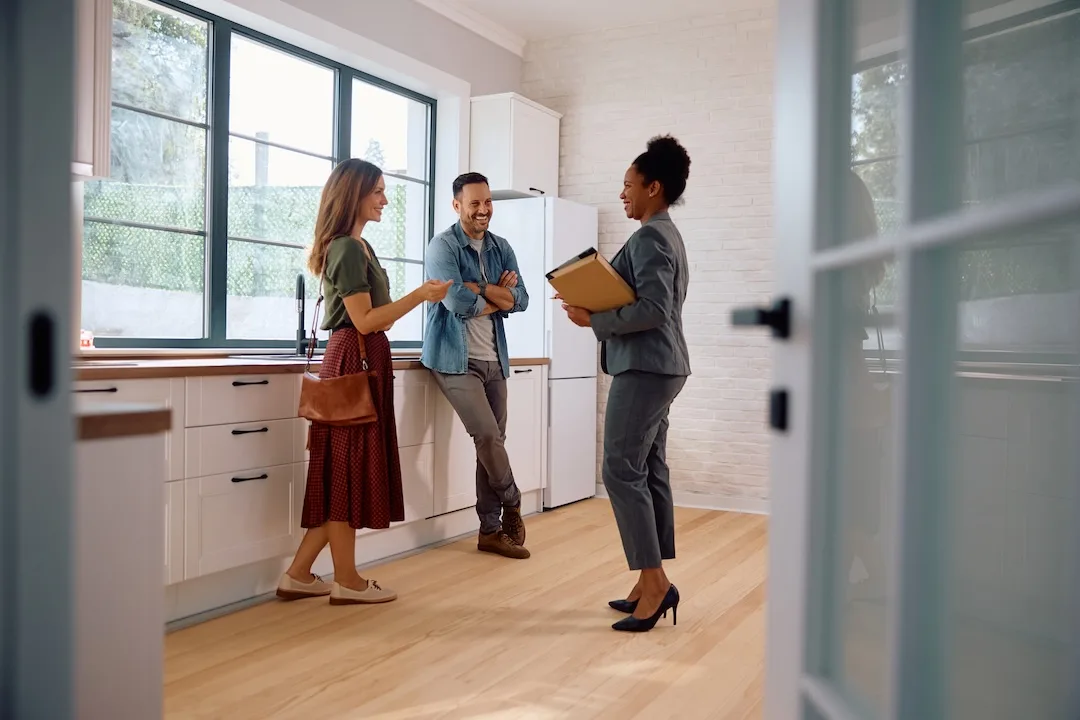 Couple talks to real estate agent.