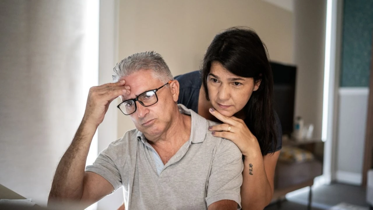 Wife giving support to worried husband at home