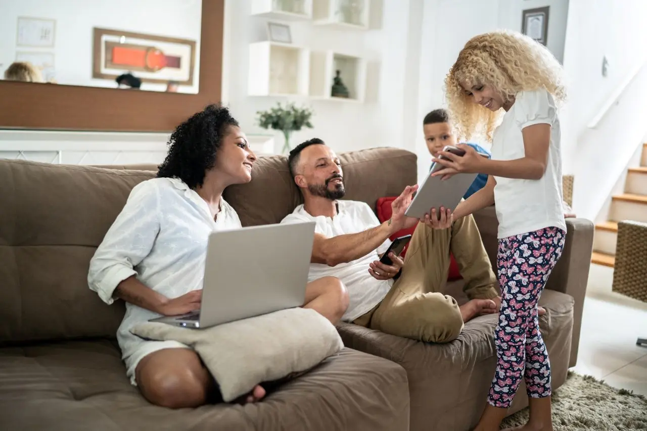 Family together at home in the living room using electronical devices