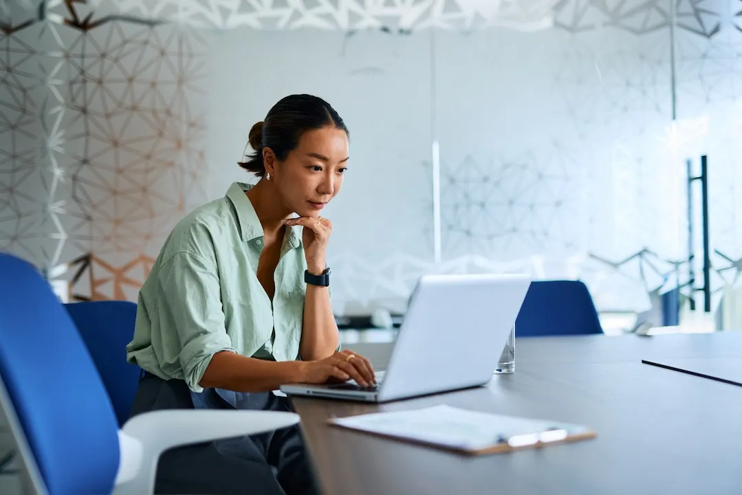 Woman weighs her loan options on a laptop.