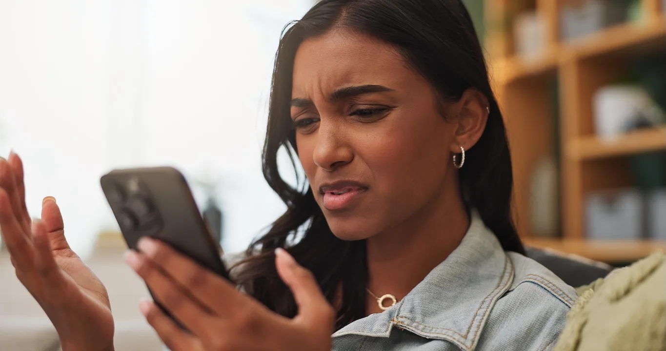 Woman looks concerned by what she's seeing on her phone. 