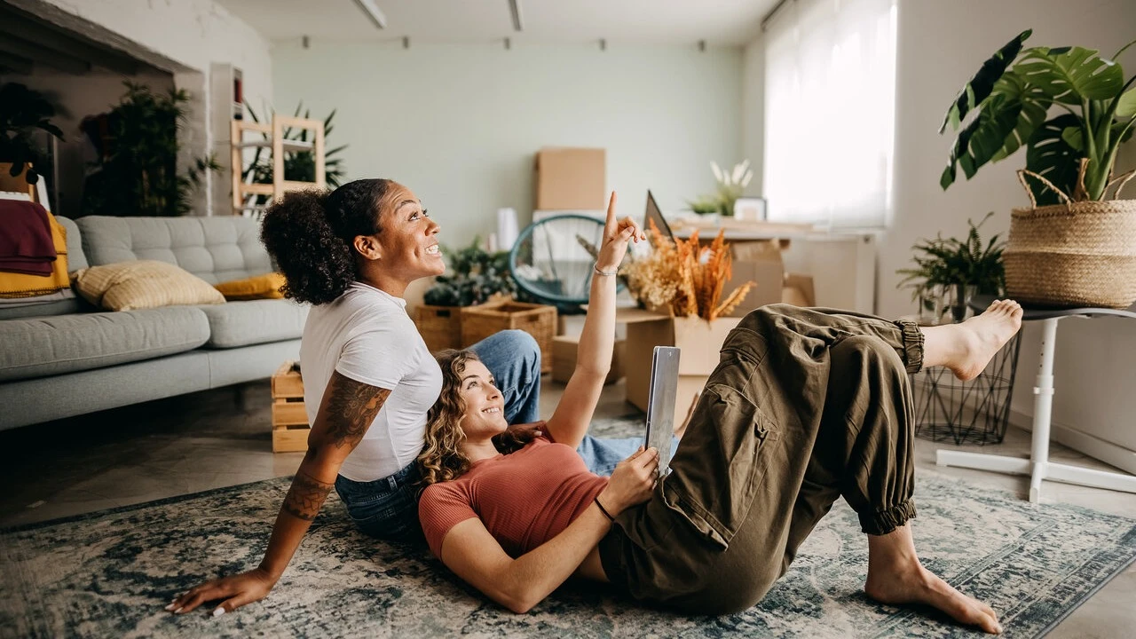 Two best young female friends are fixing up their new apartment together
