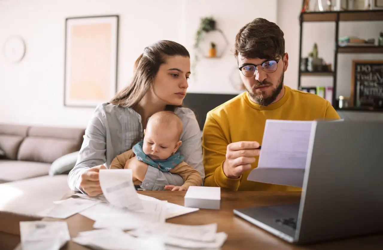 Young family with baby worried about family budget and high taxes and bills. 