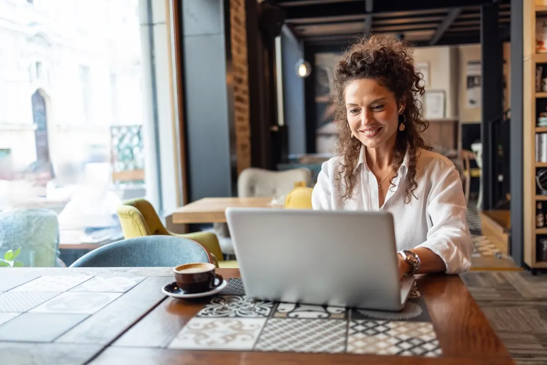 Woman using laptop in a cafe.