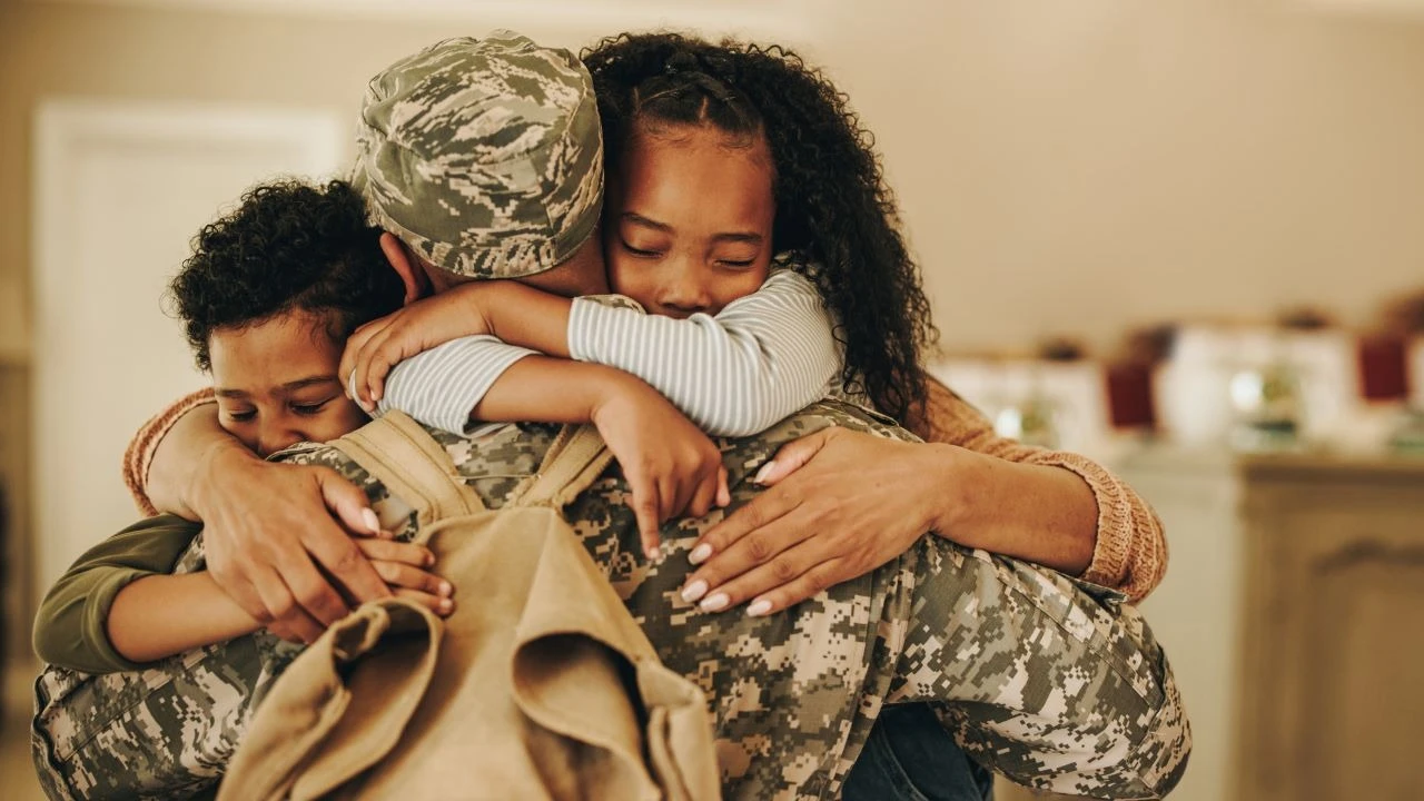 Soldier embracing his wife and kids on his homecoming. 