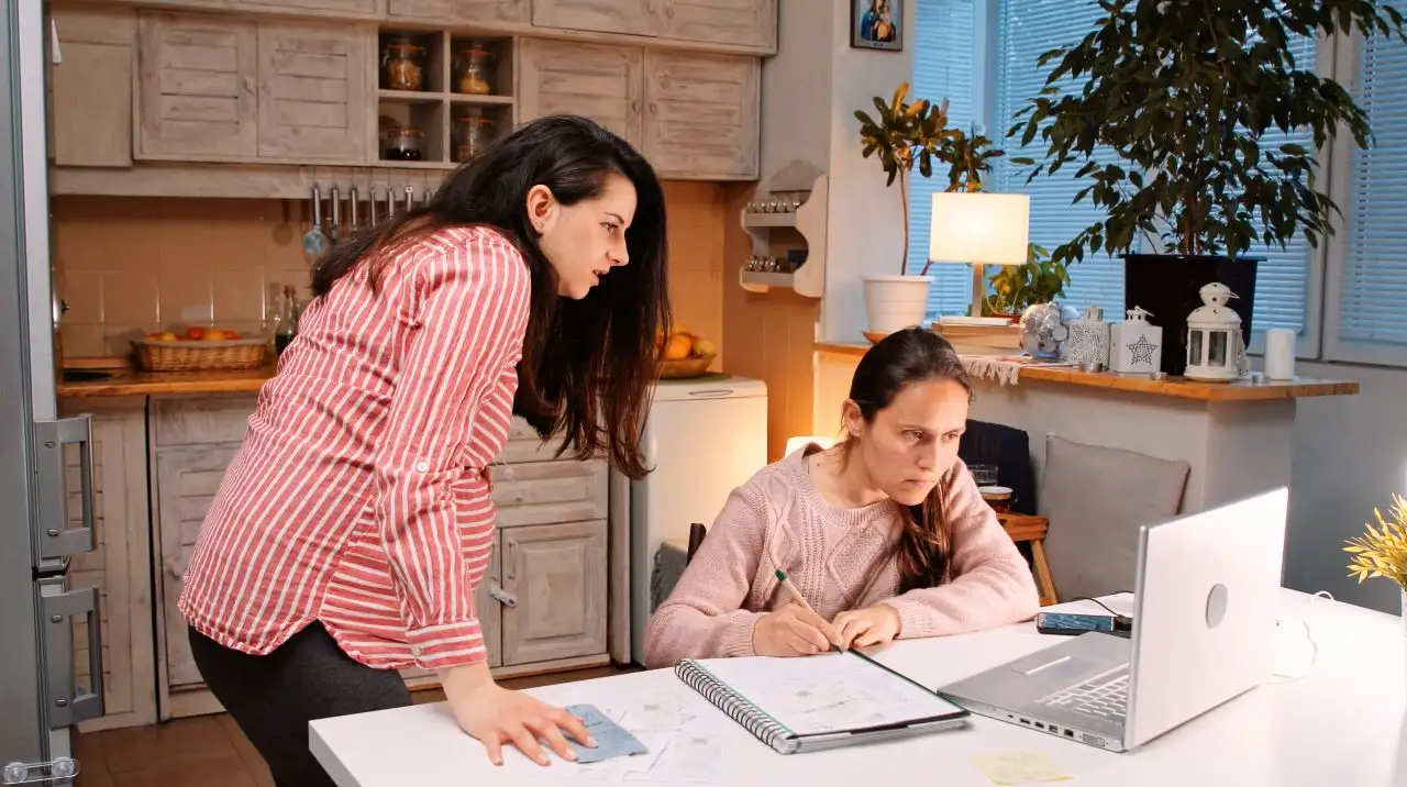 Gen Z pregnant girl helping her friend to do her budget. Looking together through bills and household expenses for the month.
