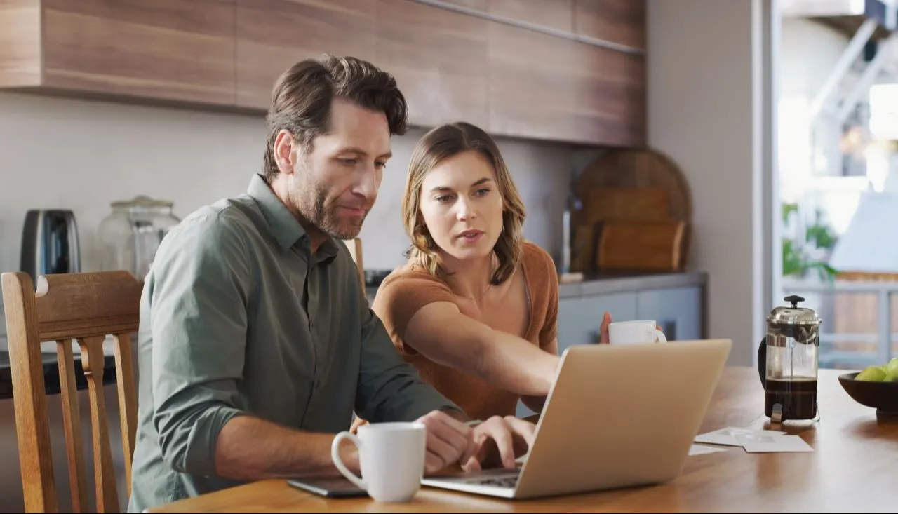 Young couple using a laptop while going over their finances together at home