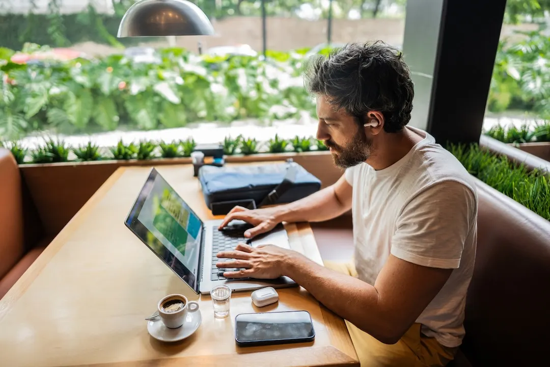 Person works at laptop in a cafe.