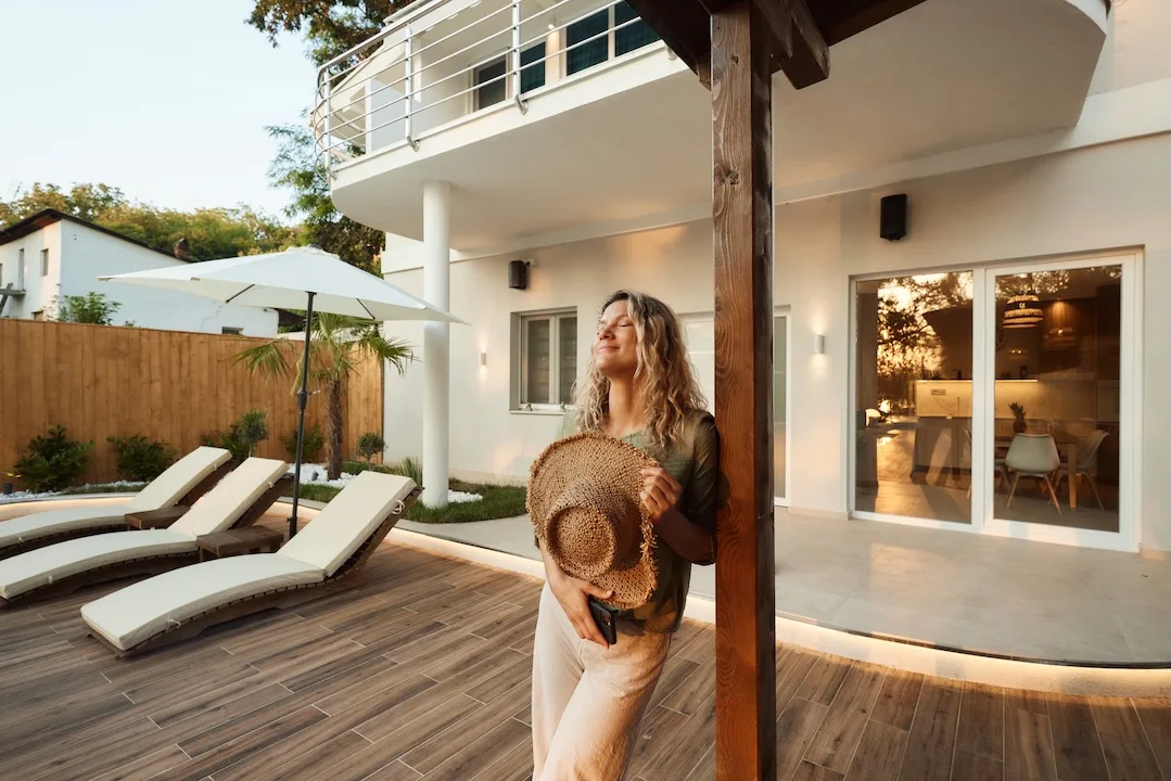Woman enjoys resort home backyard.