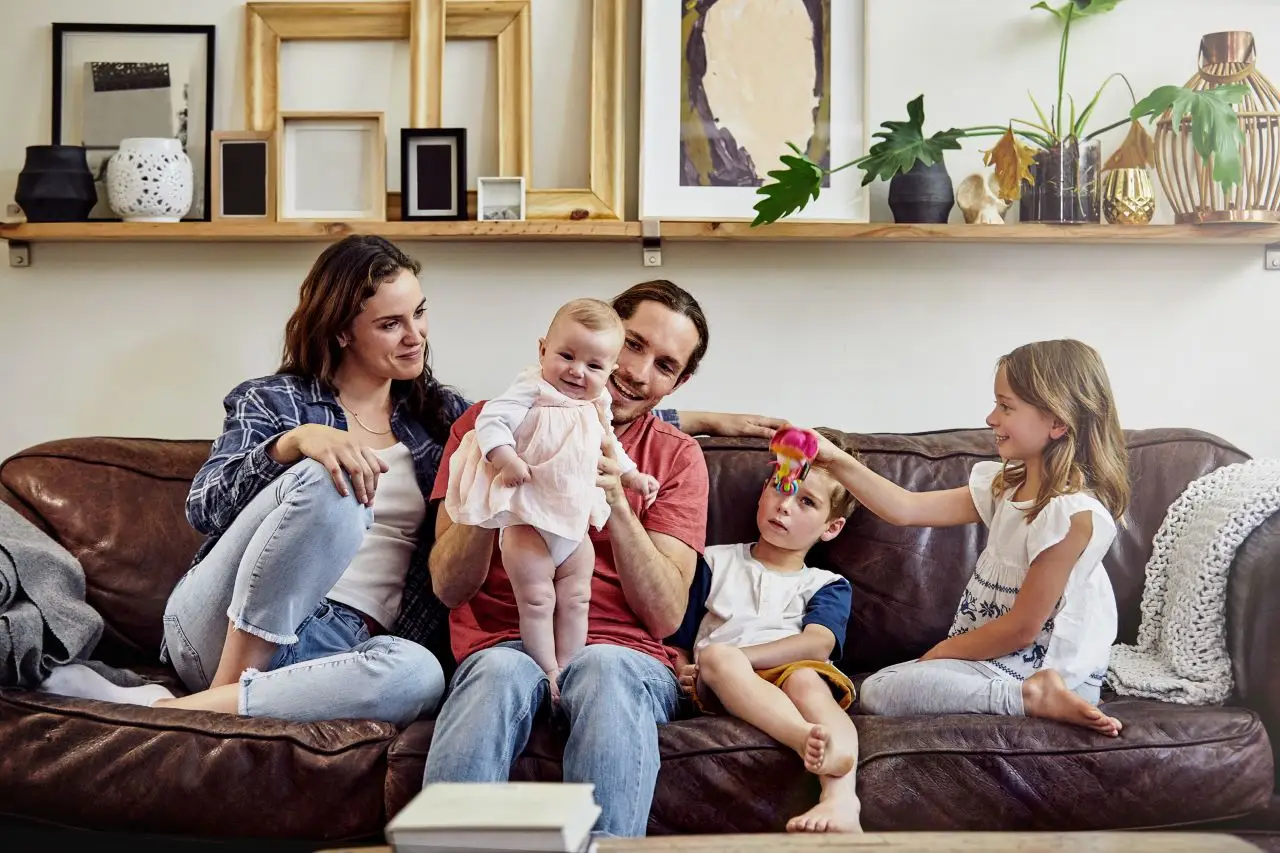 Happy couple with three children on couch