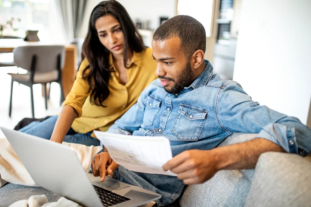 Couple pays bills on a laptop together