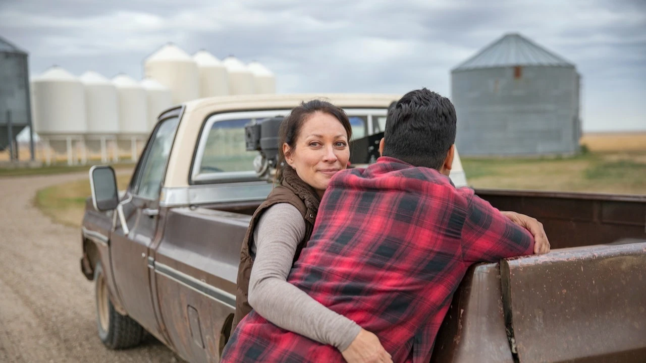 Young couple standing near pickup truck on farm
