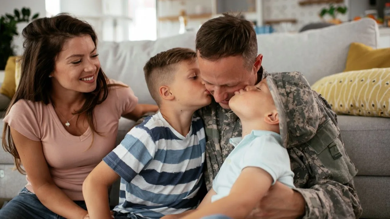Happy soldier sitting on the floor with his family. Soldier and his wife enjoying at home with children
