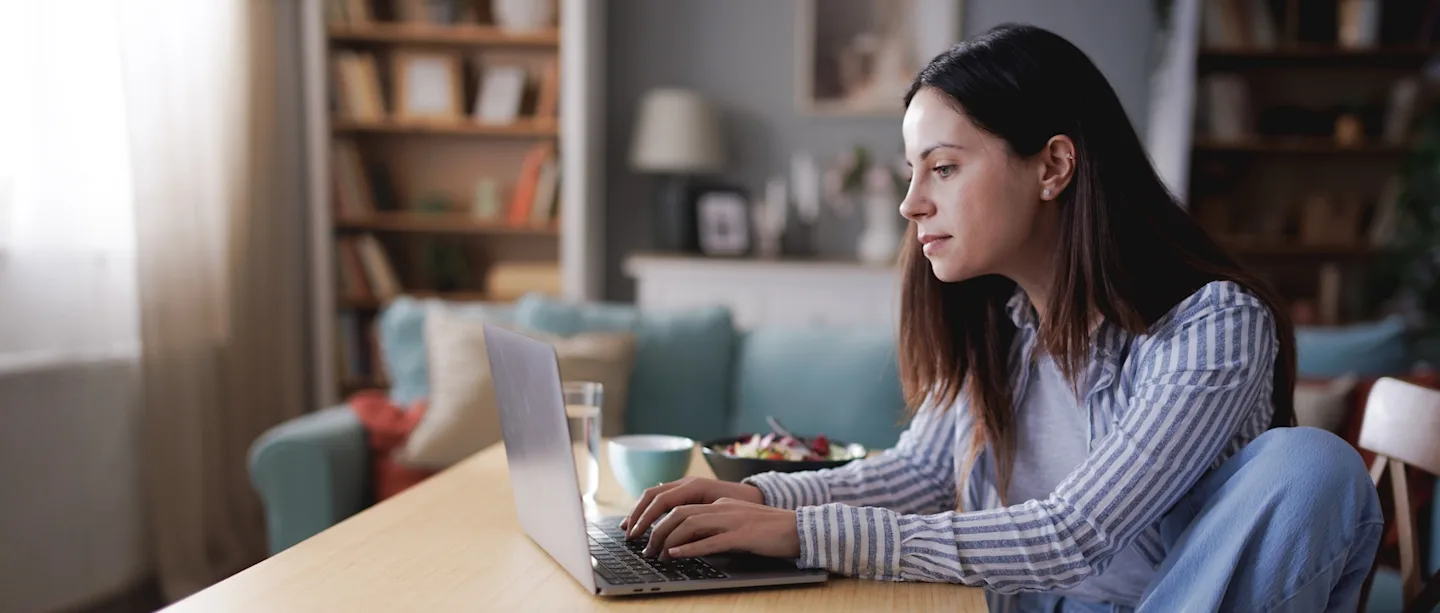 Woman eating lunch at her laptop. 