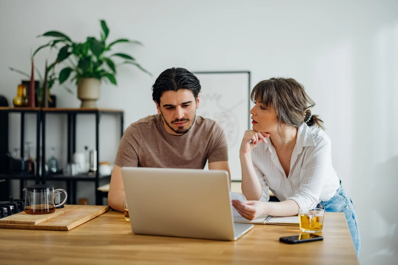 Couple exploring debt payoff options on a laptop. 